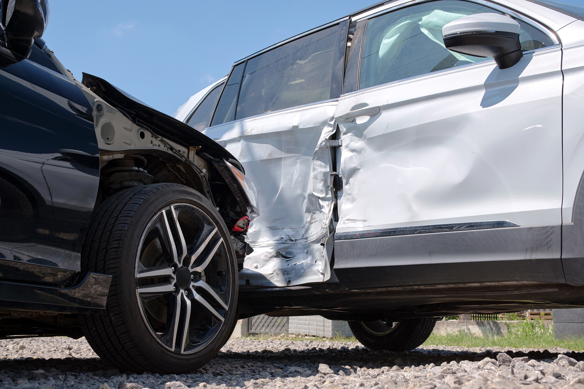 Damaged in heavy car accident vehicles after collision on city street crash site. Road safety and insurance concept